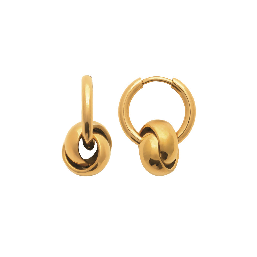 A pair of gold huggie hoop earrings with a knotted ball charm, shown on a solid white background.