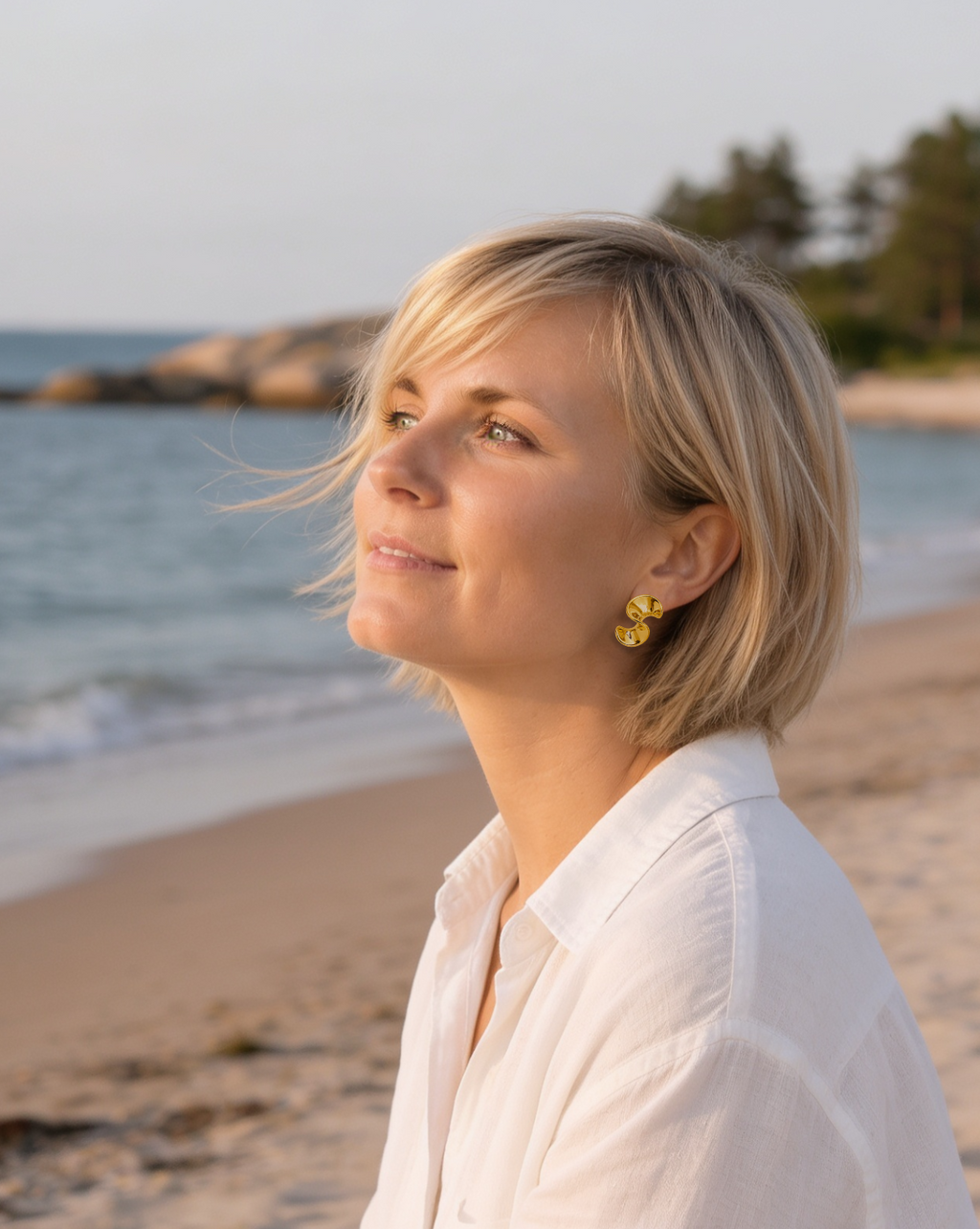 Model wearing gold-tone steel organic curve stud earrings by HNKO