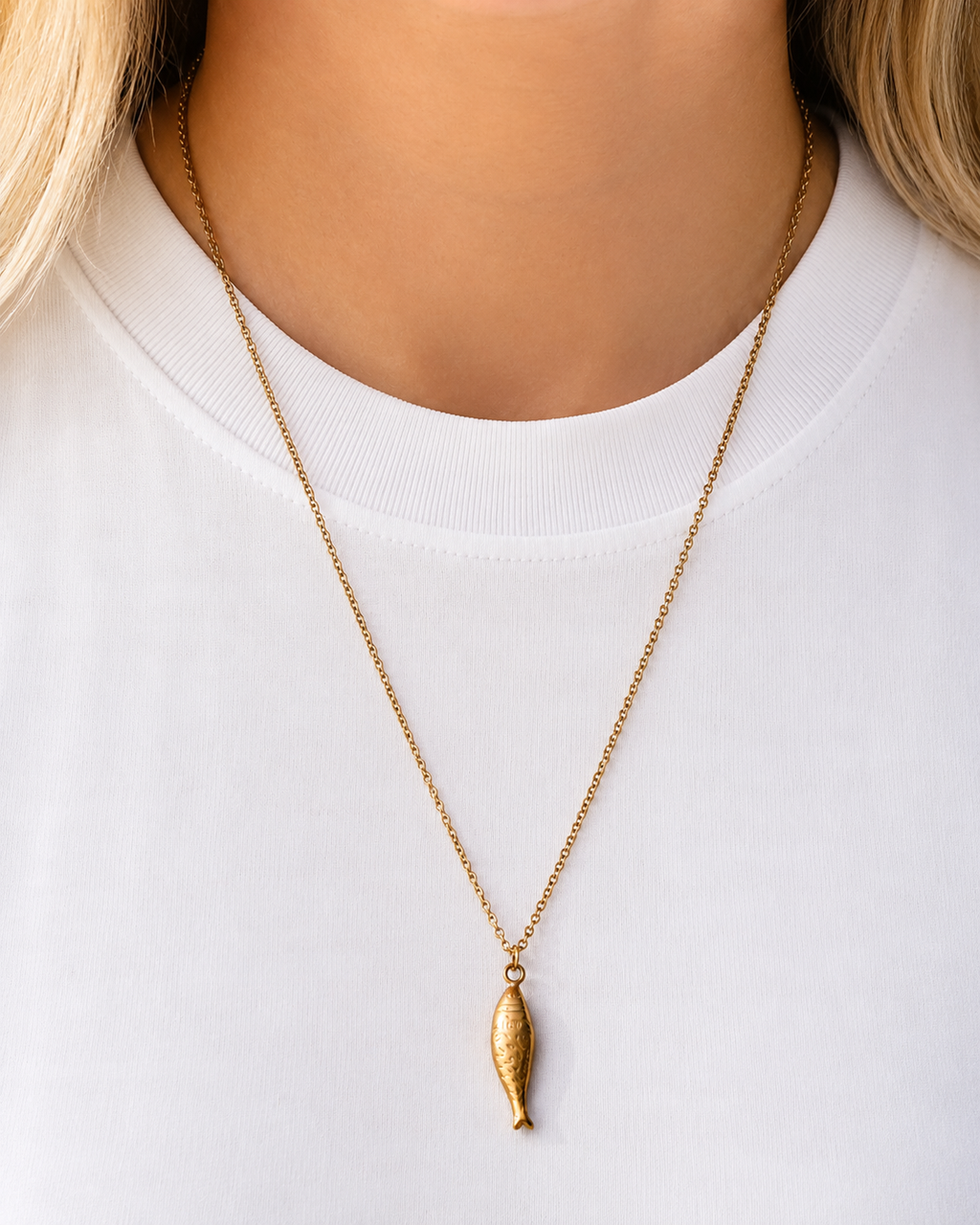 Gold-tone fish pendant necklace inspired by Nordic coastal life worn by a model by HNKO