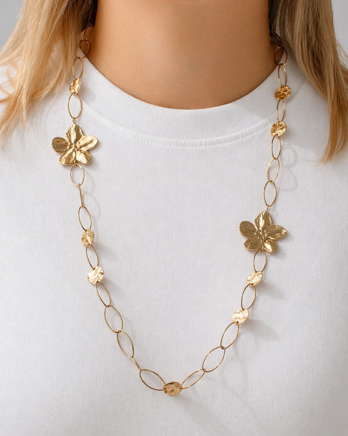 Gold-tone floral chain necklace with sculpted flower details inspired by Nordic nature worn by a model by HNKO