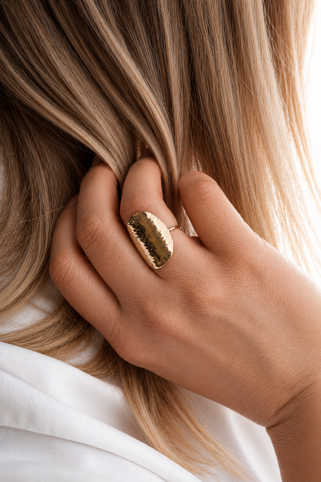 18K gold-plated hammered ring with a textured sculptural surface worn by a model by HNKO