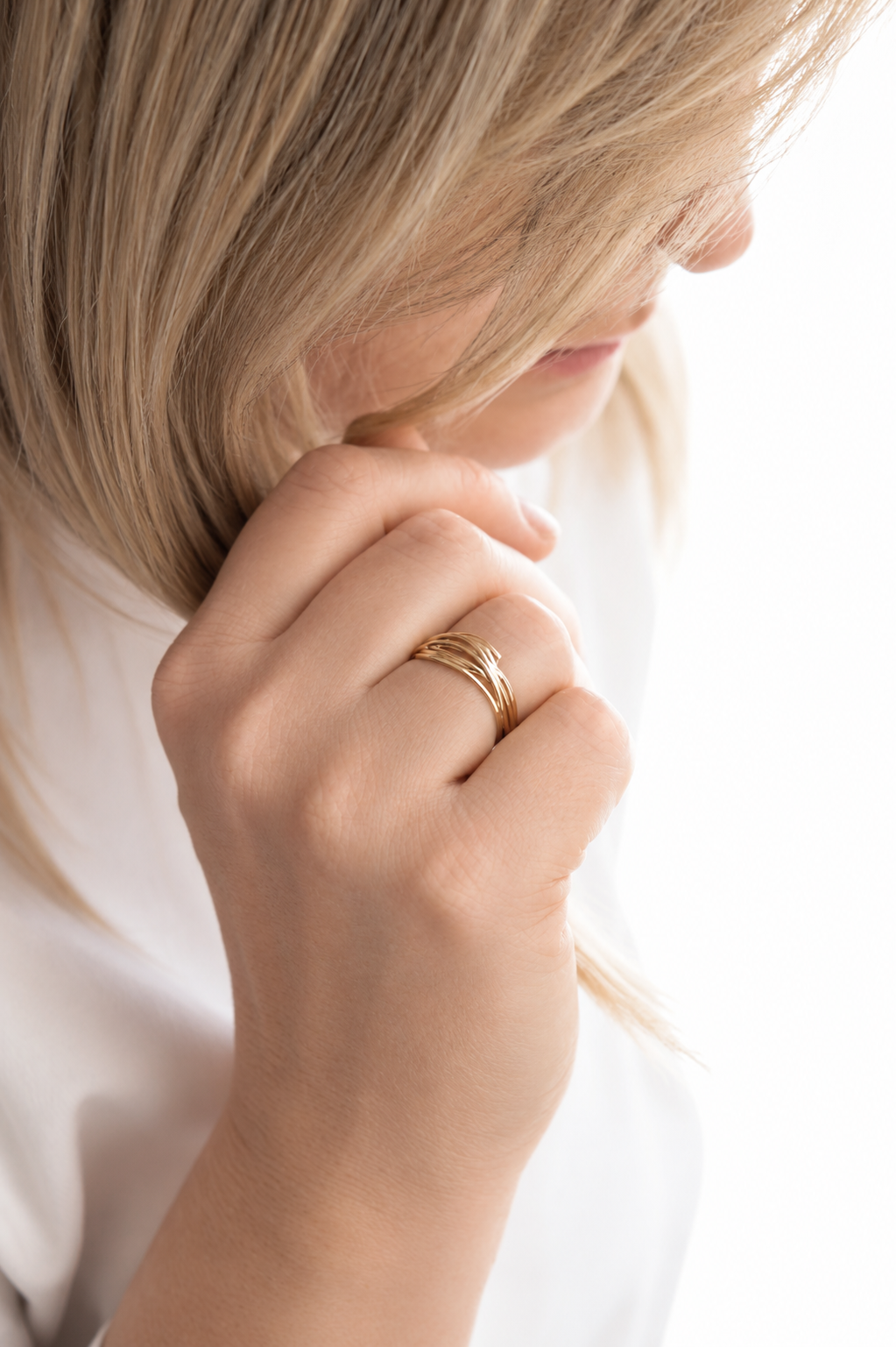 18K gold-plated interwoven band ring with flowing sculptural lines worn by a model by HNKO