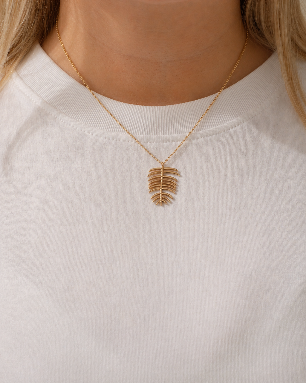 18K gold-plated leaf necklace with articulated botanical elements worn by a model by HNKO