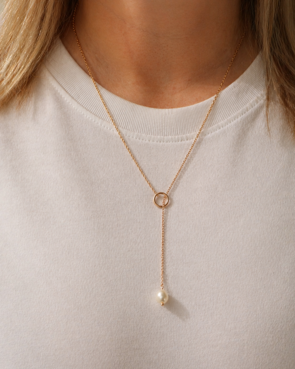 Model wearing 18K gold plated linear necklace by HNKO Finland with suspended cultured pearl pendant, showing elegant vertical silhouette and minimalist Nordic-inspired styling on neckline